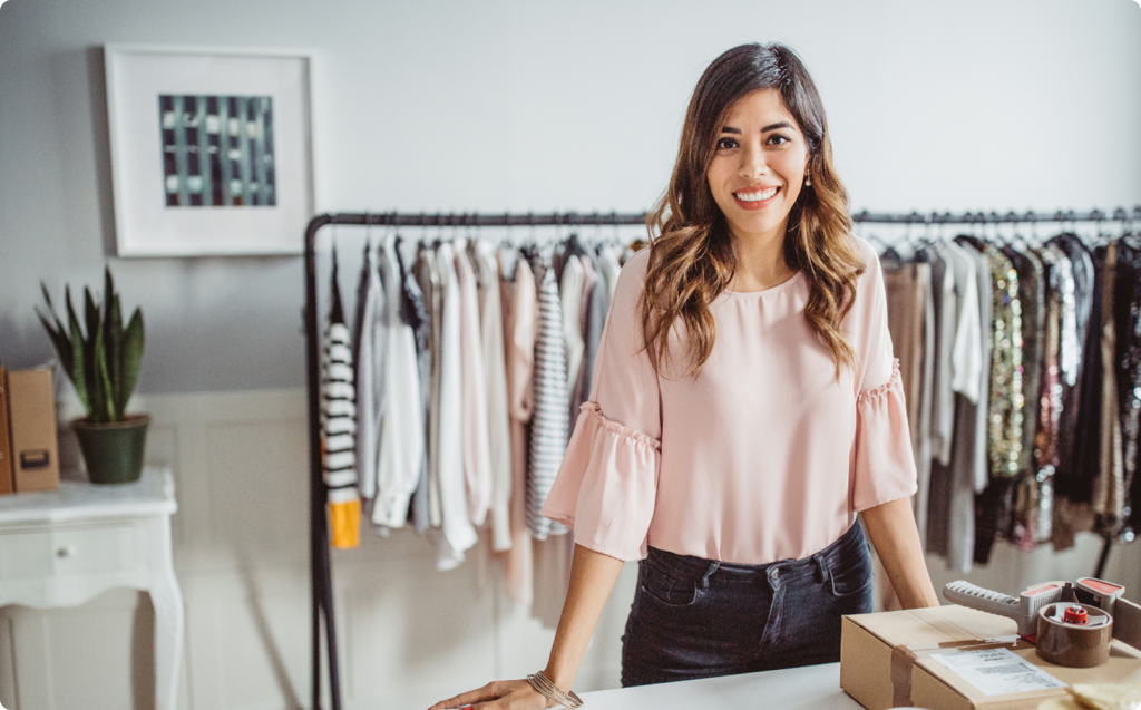 Woman standing inside her retail clothing business